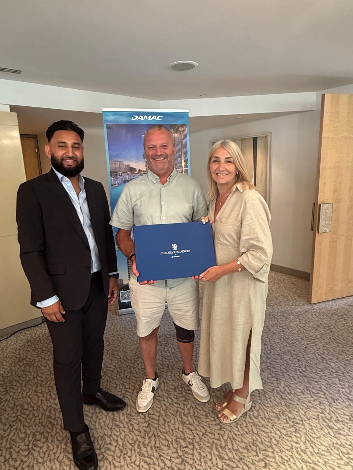 Tazz Miah with clients receiving their Chelsea Residences by DAMAC documents